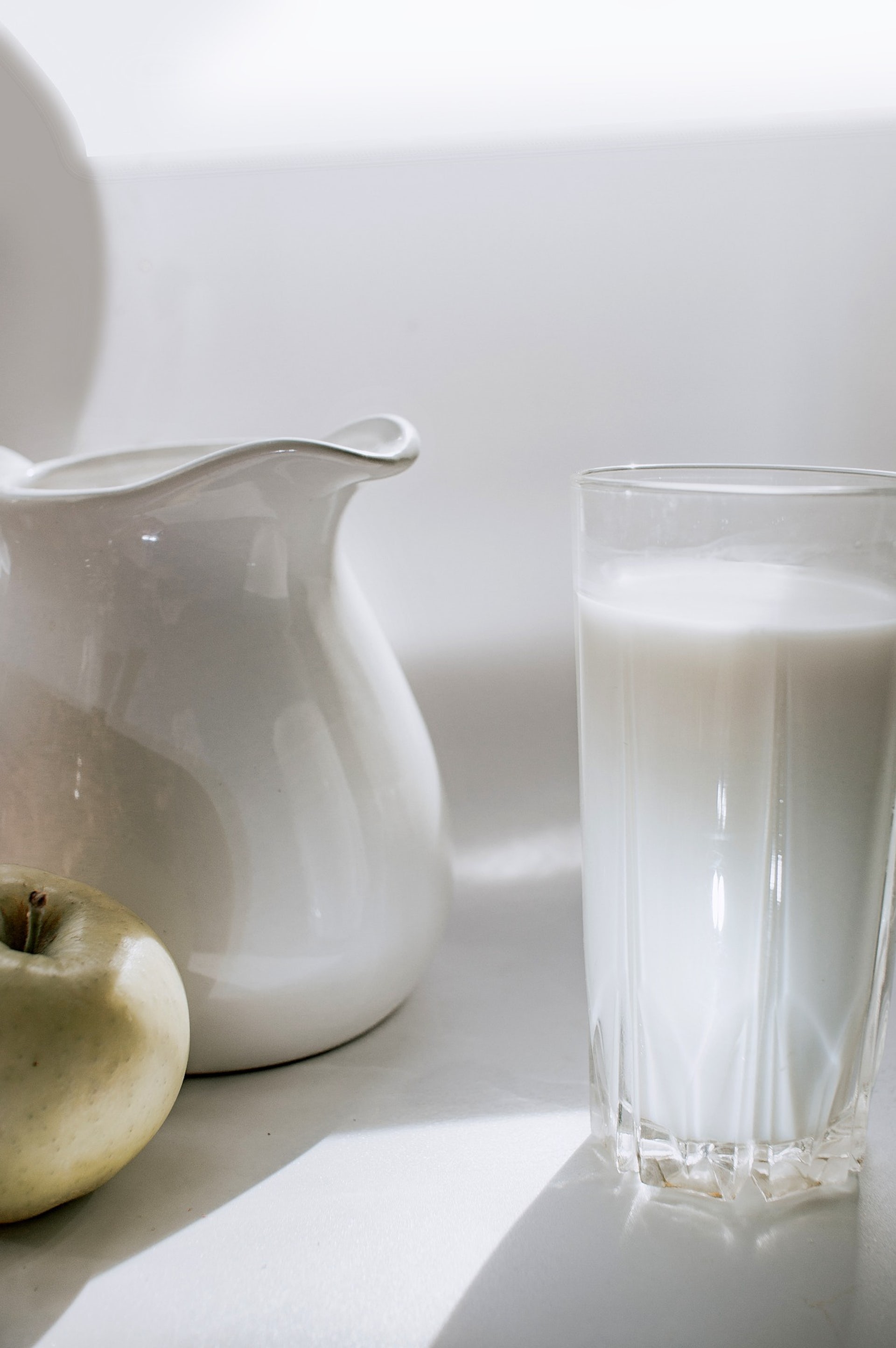 A pitcher and a glass of milk