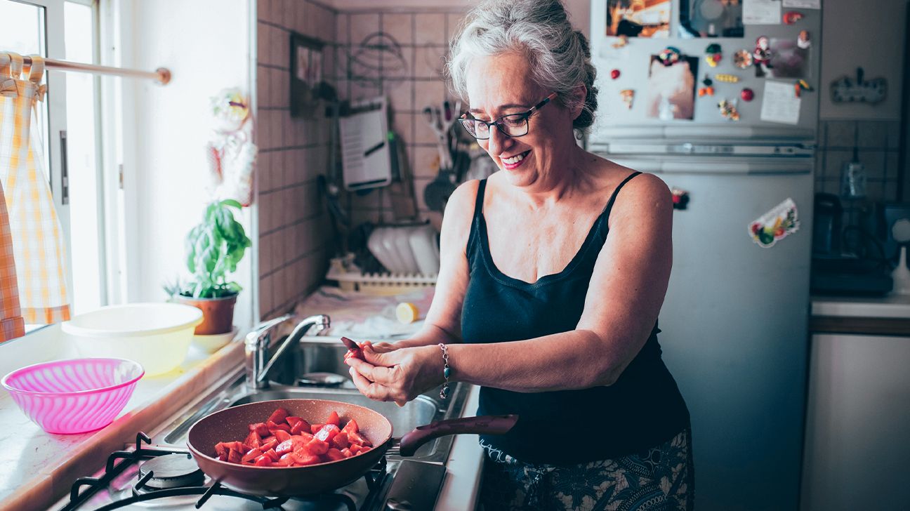 A woman cooking tomatoes.