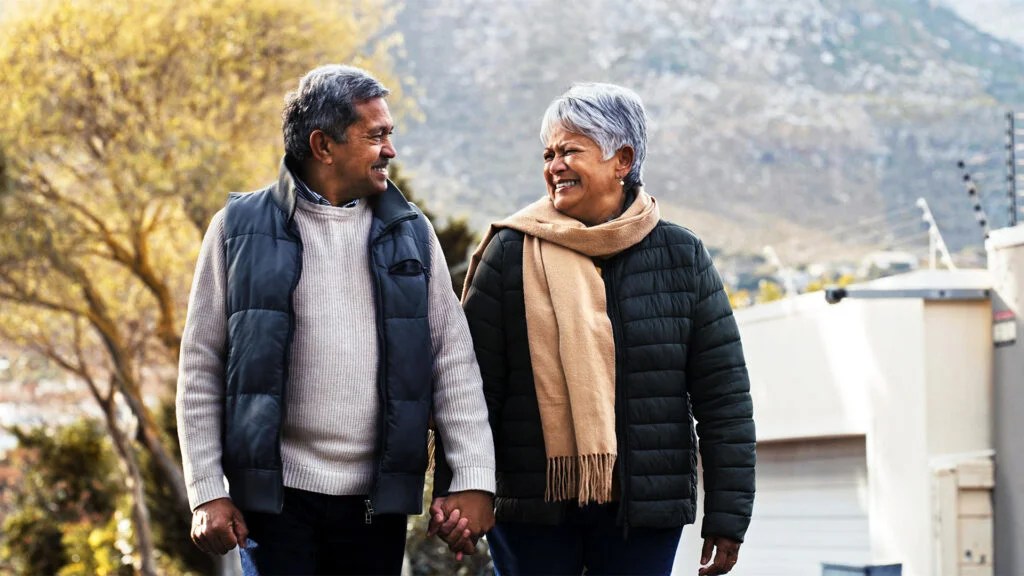 older man and woman walking holding hands