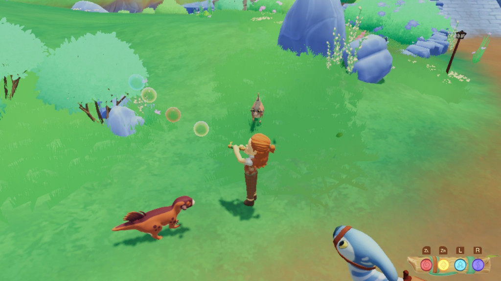 Screenshot showing a lush green along with our character and a small brown dino beside them. Small coloured bubbles of red, yellow and blue are rising from a magical flute that we are playing to entice the dino. Lucky looks on at the bottom of the screen.