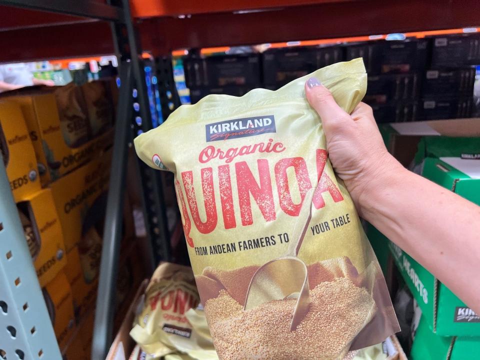 hand holding up a bulk bag of organic quinoa at costco