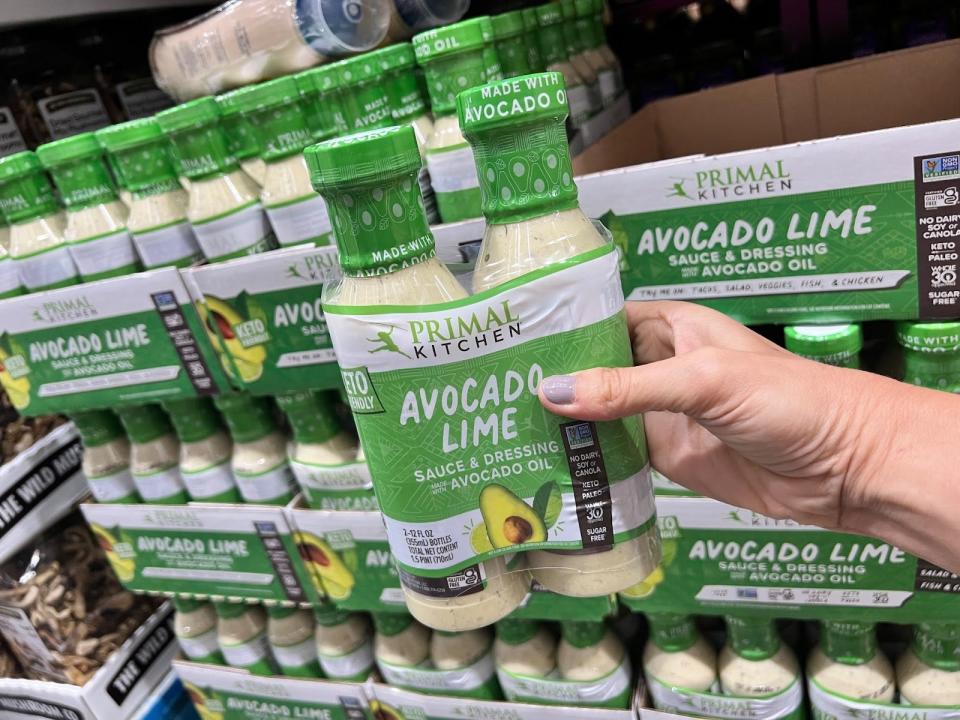 hand holding up a two pack of avocado lime dressing at costco