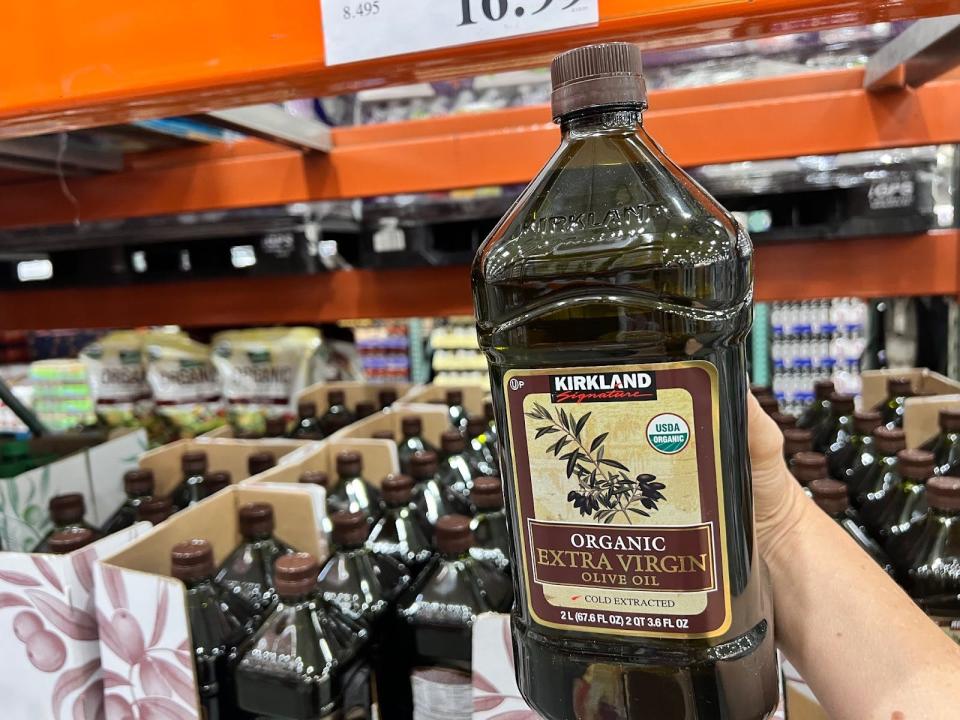 hand holding up a bulk container of organic olive oil at costco