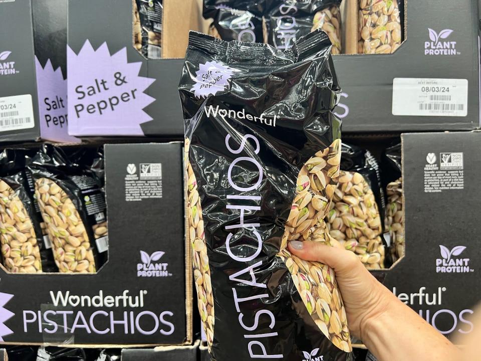someone holding up a bulk bag of pistachios at costco