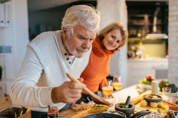 Photo of a senior couple tasting the food they have prepared together