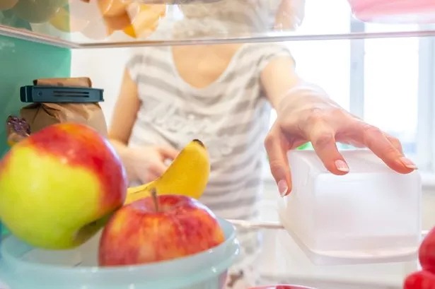 A picture of a person and an opened fridge